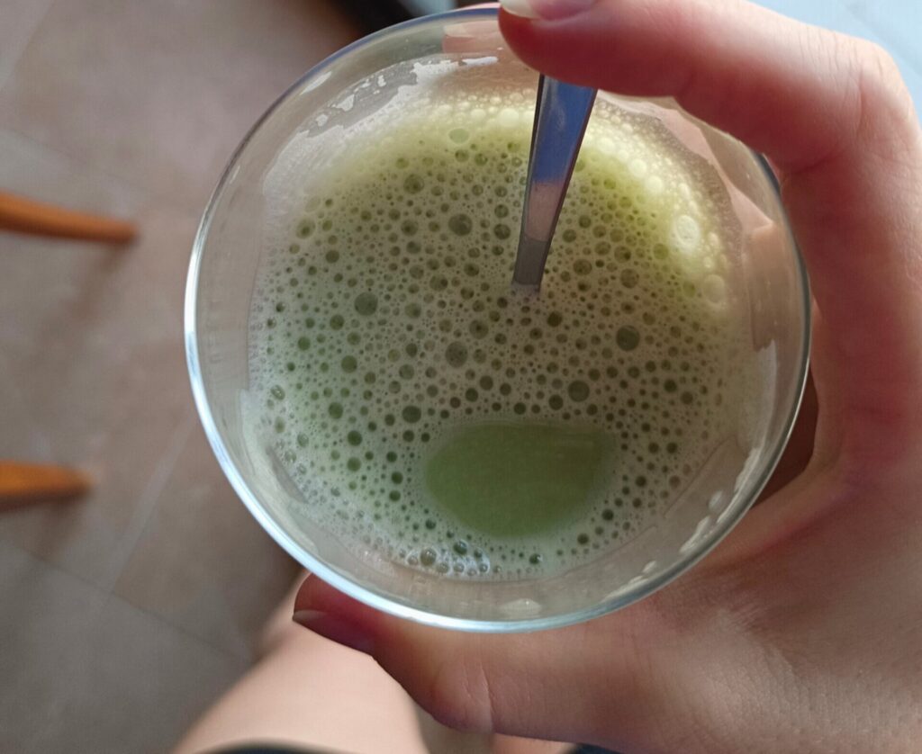 Imagen de Nitka Fitness mostrando el té matcha que está tomando en un vaso de cristal.