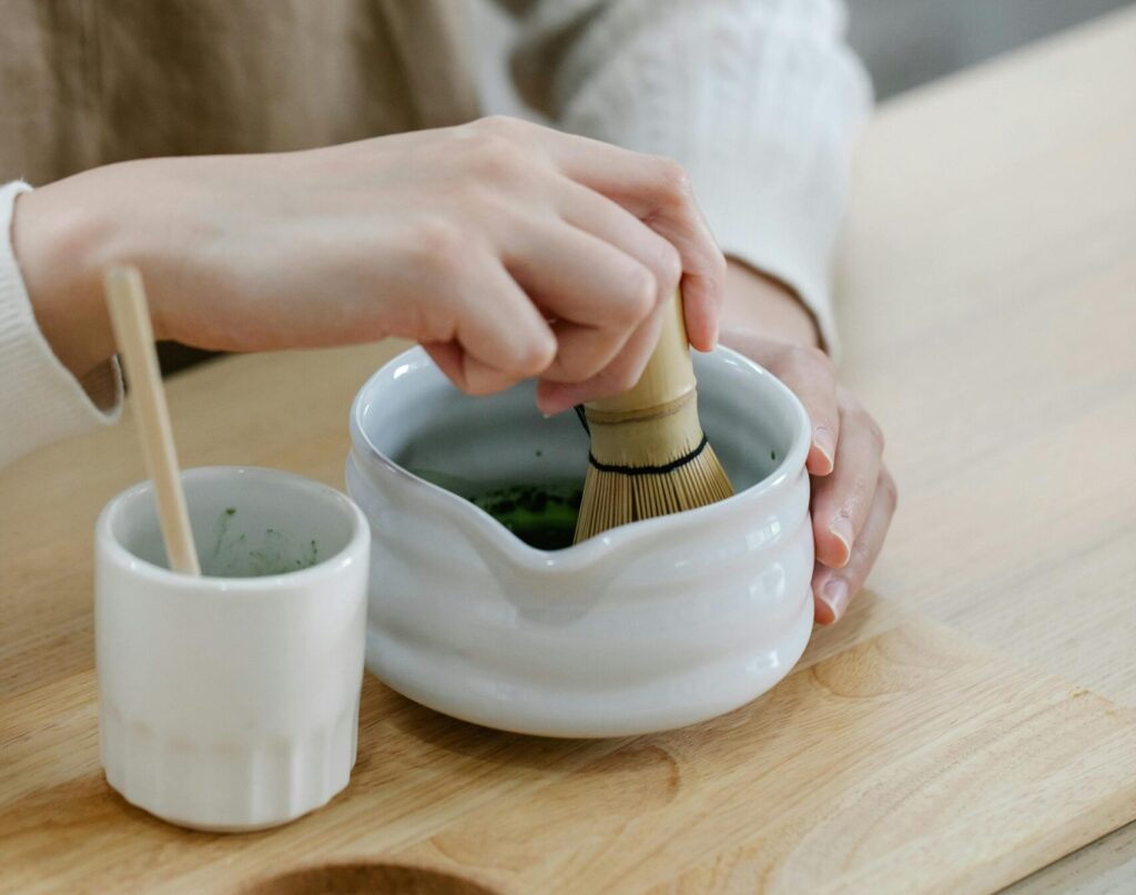 Imagen del proceso de preparación del té matcha, donde se observa el meticuloso mezclado del polvo de té con un poco de agua, buscando una dilución perfecta antes de su incorporación a la bebida de soja.